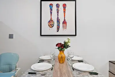 a dining room table with plates and a vase of flowers at FIRST CLASS Studio Canal & Burj Khalifa View in Dubai