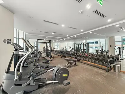 a gym with a lot of treadmills and machines at FIRST CLASS Studio Canal & Burj Khalifa View in Dubai