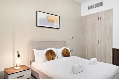 a bedroom with two beds and a picture on the wall at FIRST CLASS Studio Canal & Burj Khalifa View in Dubai