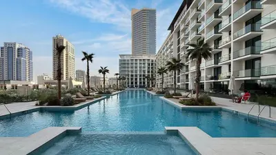 a swimming pool in the middle of a building with palm trees at Binghatti Phoenix - Luxury & Modern Studio - Pool & Gym - Free Parking - JVC in Dubai