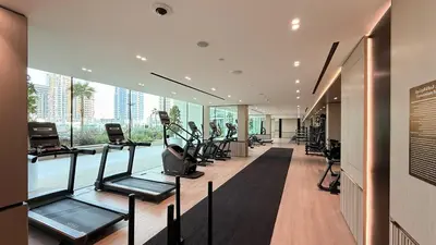 a gym with a lot of treadmills and exercise equipment at Binghatti Phoenix - Luxury & Modern Studio - Pool & Gym - Free Parking - JVC in Dubai