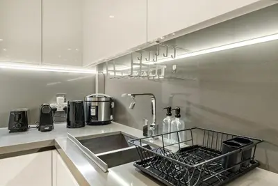 a kitchen with a sink and a dish drying rack at FIRST CLASS 2BR Modern Luxury Hideaway in Dubai