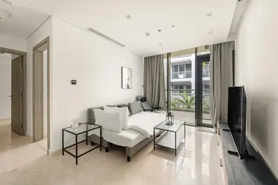 a living room with a couch and a tv at FIRST CLASS 2BR Modern Luxury Hideaway in Dubai