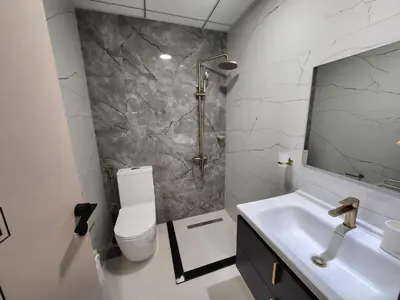 a bathroom with a sink and a toilet and a mirror at 25 Studio Skyz By Danube, Arjan in Dubai