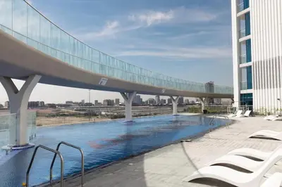 a bridge over a swimming pool on top of a building at 25 Studio Skyz By Danube, Arjan in Dubai