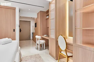 a bathroom with a bed and a table and a chair at bnbmehomes - Burj Al Nujoom in Dubai