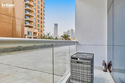 two men standing on a ledge of a building at bnbmehomes - Burj Al Nujoom in Dubai