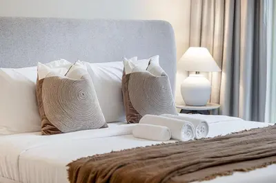 a white bed with pillows and towels on it at Blissful Living at Beach Mansion with Private Beach in Dubai