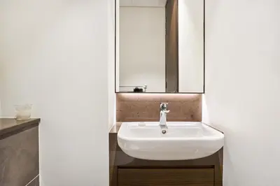 a bathroom with a white sink and a mirror at Jumeirah Living Marina Gate - Elegant 1BR Canal View Retreat in Dubai