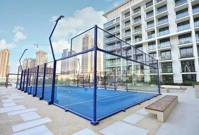 a tennis court in front of a building at Modern 1BR Hideaway In Binghatti Phoenix-JVC in Dubai