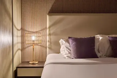 a bedroom with a bed and a lamp on a table at Waterfront 2BR District One Residence - Near Downtown and Lagoon in Dubai