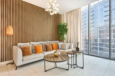 a living room with a couch and a table at Waterfront 2BR District One Residence - Near Downtown and Lagoon in Dubai