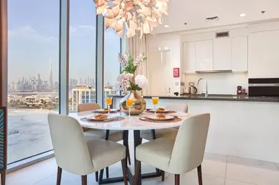 a kitchen and dining room with a table and chairs at Waterfront 2BR District One Residence - Near Downtown and Lagoon in Dubai