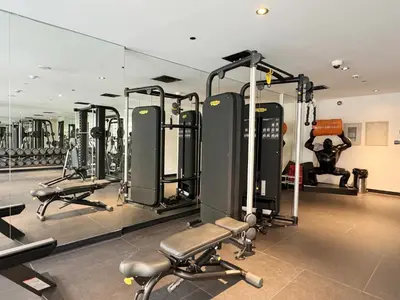 a gym with a row of treadmills and machines at Joya Blanca Residence - Bright 1BR Apartment in Arjan in Dubai