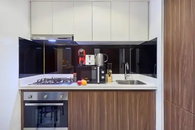 a kitchen with a sink and a stove top oven at Reva Residences 1BR - Near Downtown Dubai & Canal Walk in Dubai