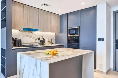 a kitchen with a counter with fruit on it at Stylish 1BR near Miracle Garden - Oxford Gardens in Dubai