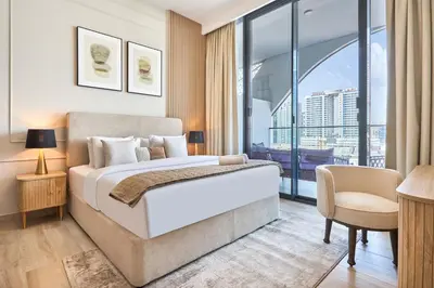 a bedroom with a bed and a large window at Stylish 1BR near Miracle Garden - Oxford Gardens in Dubai