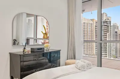 a bedroom with a bed and a dresser and a window at FIRST CLASS 1BR Panoramic Marina Views in Dubai