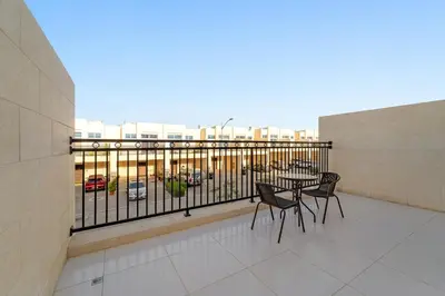 a balcony with a table and chairs on a building at FIRST CLASS Villa Peaceful Pool View Retreat in Dubai