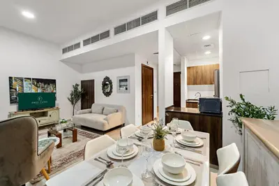 a dining room and living room with a table and chairs at FIRST CLASS Villa Peaceful Pool View Retreat in Dubai