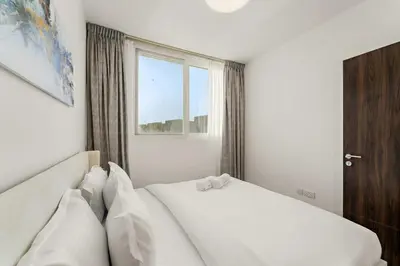 a bedroom with a white bed and a window at FIRST CLASS Villa Peaceful Pool View Retreat in Dubai