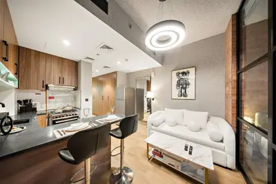 a living room with a white couch and a kitchen at FIRST CLASS 1BR Elegant Cozy Escape in Dubai