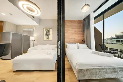 two beds in a hotel room with a window at FIRST CLASS 1BR Elegant Cozy Escape in Dubai