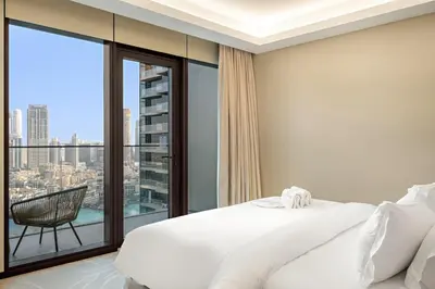 a bedroom with a white bed and a large window at FIRST CLASS 2BR Burj Khalifa & Fountain View in Dubai