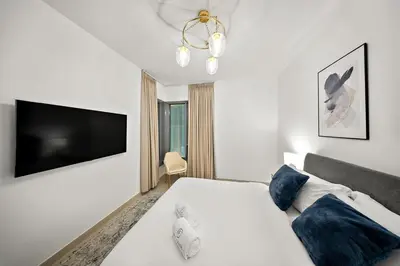 a bedroom with a bed and a flat screen tv at FIRST CLASS 1BR Sophisticated Downtown Escape in Dubai
