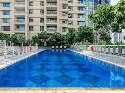 a blue swimming pool in front of a tall building at FIRST CLASS 1BR Sophisticated Downtown Escape in Dubai