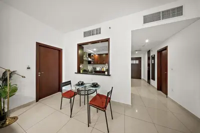 a dining room with a glass table and chairs at FIRST CLASS 1BR Sophisticated Downtown Escape in Dubai