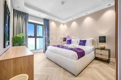 a bedroom with a large bed with purple pillows at Amazing 2BR Princess Tower Dubai Marina in Dubai