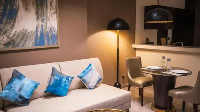 a living room with a white couch with blue pillows at Downtown Dubai Mall Walkable 8 min in Dubai