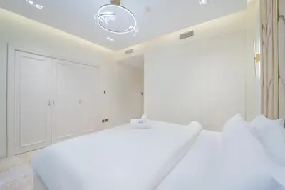 a white bedroom with white cabinets and a bed at Zaafaran 1- Luxury 2BR Apt Near Burj Khalifa & Dubai Mall in Dubai