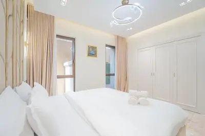 a white bedroom with a large bed with white pillows at Zaafaran 1- Luxury 2BR Apt Near Burj Khalifa & Dubai Mall in Dubai