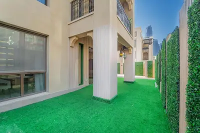 an empty courtyard of a building with green grass at Zaafaran 1- Luxury 2BR Apt Near Burj Khalifa & Dubai Mall in Dubai