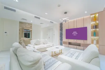a living room with white furniture and a purple screen at Zaafaran 1- Luxury 2BR Apt Near Burj Khalifa & Dubai Mall in Dubai