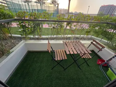 two chairs and a table on a balcony at Wavez 06 Well Furnished Studio in Liwan in Dubai