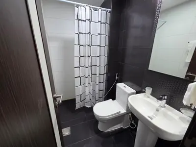 a bathroom with a white toilet and a sink at Wavez 06 Well Furnished Studio in Liwan in Dubai