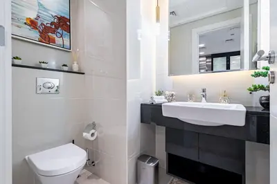 a white bathroom with a sink and a toilet at Ultra-Luxe Breathtaking Canal Views l Business Bay in Dubai