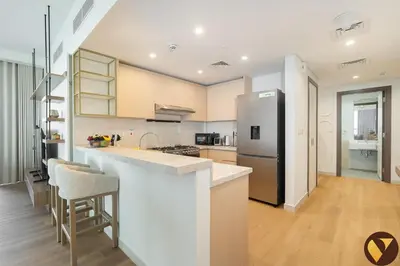 a kitchen with a counter and a refrigerator at Vogue Al Wasl 1 Residences Near Zabeel Park and World Trade Centre, Two Bedroom Apartment with Balcony with City View, Access to all Amenities, Walkable to Max Fashion Metro Station in Dubai