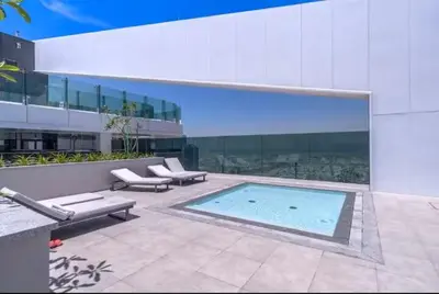 a building with a swimming pool in front of a building at Vogue Al Wasl 1 Residences Near Zabeel Park and World Trade Centre, Two Bedroom Apartment with Balcony with City View, Access to all Amenities, Walkable to Max Fashion Metro Station in Dubai