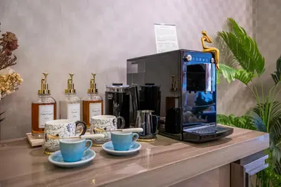a table with a coffee maker and cups and bottles of alcohol at City View Lux 1 BR in Creek Heights Upgraded by UDH in Dubai