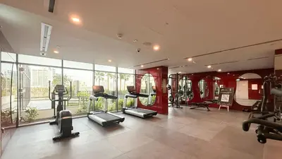 a gym with treadmills and ellipticals in a room at Hadley Heights! Pool & Gym Access! 2 Double Bed, Balcony with a Great View! in Dubai