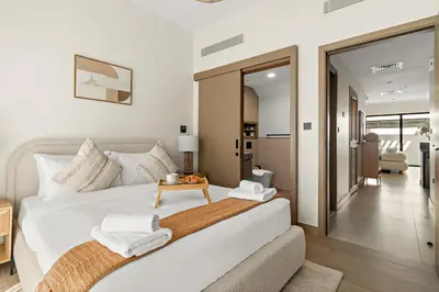 a bedroom with a large white bed and a table at VayK - Modern 4 BD Townhouse with Private Garden in Damac Lagoons in Dubai