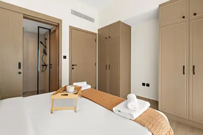 a bedroom with a large white bed with a table at VayK - Modern 4 BD Townhouse with Private Garden in Damac Lagoons in Dubai