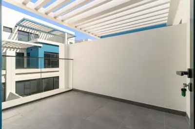an empty room with a white wall and glass doors at VayK - Modern 4 BD Townhouse with Private Garden in Damac Lagoons in Dubai