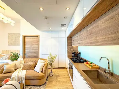 a living room with a couch and a kitchen at Barsana - Seabreeze Suite - 2 Bed - Sea Views in Dubai