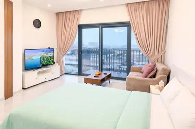 a bedroom with a bed and a tv and a balcony at City Glow Comfort Studio - Oasis Pool in Dubai