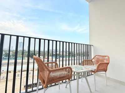 two chairs and a table on a balcony with a view at City Glow Comfort Studio - Oasis Pool in Dubai